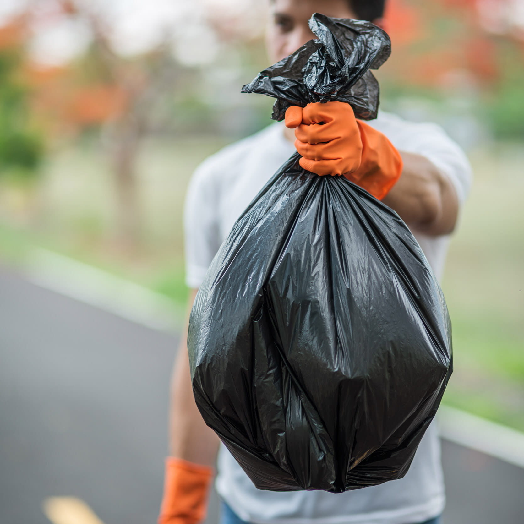 a-man-wearing-orange-gloves-collecting-garbage-in-2022-02-03-06-21-37-utc-min